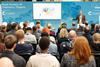 An audience listening to a speaker at a conference