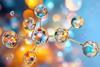 3D illustration of a molecule made up of clear spheres on an out of focus blue and yellow background