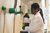 Woman holding DCM bottle in chemistry laboratory