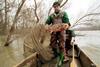 Fisherman holds up a fish poisoned by cyanide on the Tisza river