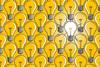 Lit light bulb in a sea of unlit light bulbs