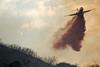 A plane drops fire retardant on a wildfire
