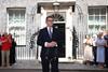 Andy Burnham standing outside 10 Downing Street. In front of him are some microphones and behind him is a small crowd of clapping people