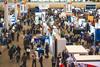 A busy conference exposition floor at Pittcon with attendees moving between stands