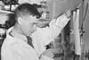Dr Richard Laurence Millington Synge looking at some paper in a lab