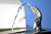 Close up of a public drinking fountain with a spout of water flowing out