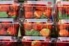 Strawberry berries in a plastic box ready for sale.