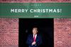 An image showing Donald Trump next to a Merry Christmas sign