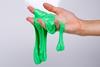 Child plays with a cloudy glitter green slime over white background