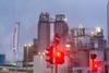 Red traffic light in front of Evonik flag and factory