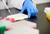Scientist pipetting liquid into vials