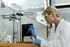 Woman pipetting in a lab fumehood