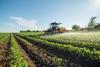 Farmer spraying soybean field with pesticides and herbicides