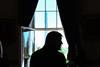 Trump stands silhouetted by a window in the White House