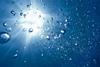 Looking up through water to the sun shining through and bubbles rising to the surface