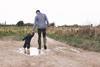 Father walking down muddy lane with child
