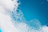 Detergent foam bubble on water with blue background.