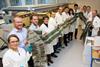 scientists holding long flexible solar cell