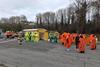 A photograph showing teams of emergency responders and a decontamination tent set up in a car park