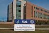 FDA Building 21 stands behind the sign at the FDA campus main entrance and houses the Center for Drug Evaluation and Research.