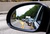 An image showing a car mirror view of incoming traffic