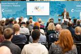An audience listening to a speaker at a conference