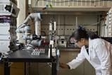 Scientist operating robotic arm in lab
