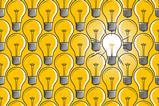 Lit light bulb in a sea of unlit light bulbs