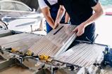 Technicians fitting batteries into an electric vehicle