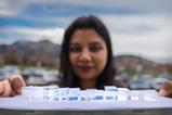 A researcher holds a tray of different sized blocks of Mochi - a thermally insulating transparent polymer