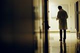 Rear view of a man in a lab coat on an empty corridor