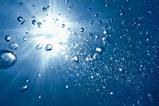 Looking up through water to the sun shining through and bubbles rising to the surface