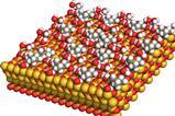 3D molecular model of a structured surface with red, yellow, and silver spheres representing atoms