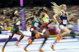 Female track runners competing in a race at a full stadium