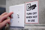 Hand on switch and "turn off when not in use" sign