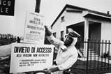 An official in protective clothing places warning signs following the Seveso disaster in 1976