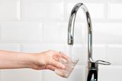 Someone filling a glass with water from a tap