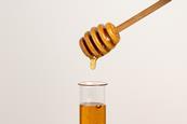 Honey dripping into a test tube