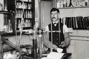 An old black and white photo of Moses Gomberg working in his lab