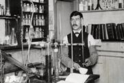 An old black and white photo of Moses Gomberg working in his lab