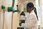 Woman holding DCM bottle in chemistry laboratory