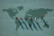 Young people walking away from the US on a large map of the world