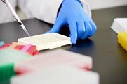 Scientist pipetting liquid into vials