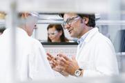 Two scientists talking in a laboratory environment.