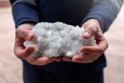 Pair of hands holding a white aggregate rock of crystals