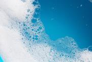 Detergent foam bubble on water with blue background.