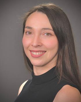 Portrait of Varinia Bernales, principle investigator at El Agente, pictured on a grey background