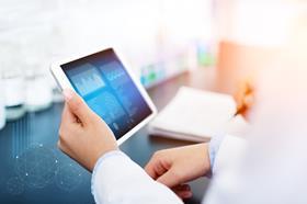 Person holding tablet showing data in a lab environment