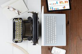 image shows old fashioned typewriter opposite a laptop