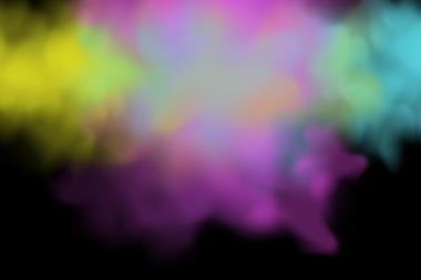 A cloud of colourful gases in yellow, pink and blue on a black background